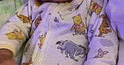 Jakobee joined the competition — help win amazing prizes! baby, infant, onesie, winnie_the_pooh, cartoon_print, blanket, clothing, cute, face, expression, child, portrait, indoors, sleepwear, soft, relaxed, young, person, hand, lying_down