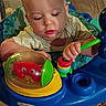 activity_center, baby, carpet, child, closeup, colorful, couch, development, expression, face, feet, furniture, hands, indoor, infant, person, plastic_toy, playing, striped_clothing, toy