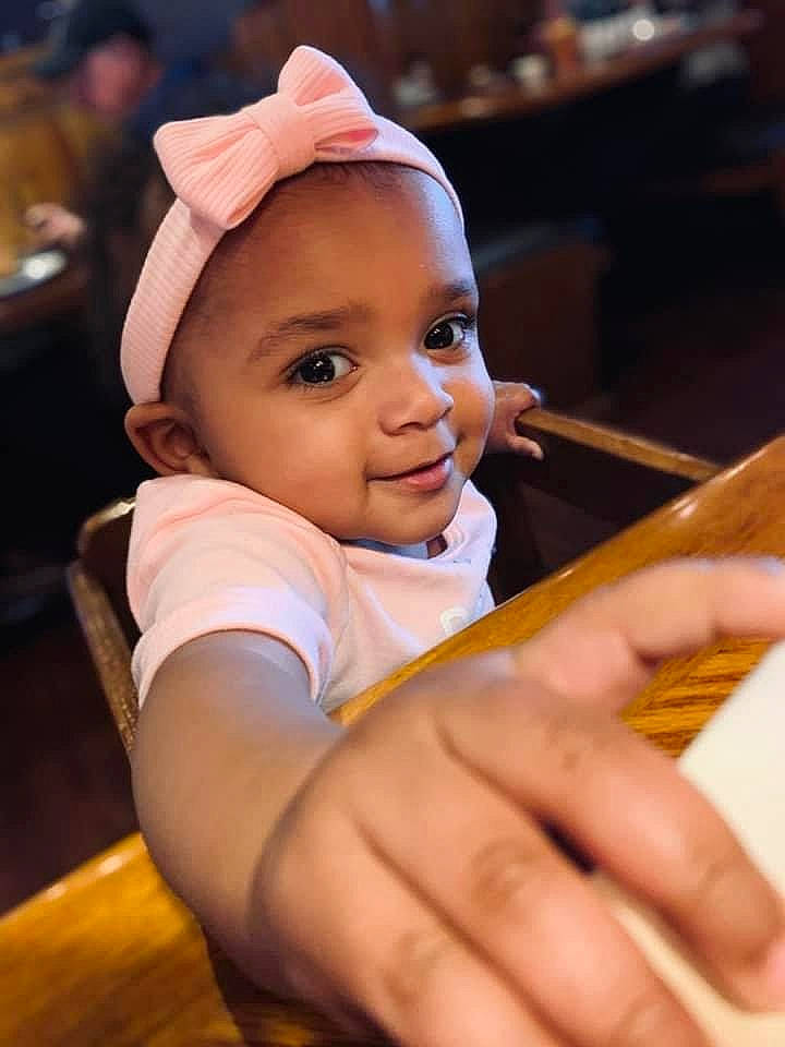 Kahlia is registered to the contest to win money with this photo: baby, baby_toddler_clothing, cap, cheek, child, eyebrow, facial_expression, flash_photography, fun, gesture, hand, happy, hat, headwear, joy, nail, person, sitting, skin, smile