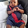 Krue is registered to the contest to win money with this photo: baby, infant, blanket, couch, leather, clothing, footwear, shoe, sneaker, person, child, indoors, relaxing, cute, portrait, smiling, comfortable, furniture, home, young
