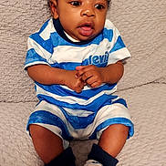 Krue joined the competition — help win amazing prizes! baby, child, infant, blue_striped_clothing, socks, hands, face, eyes, curly_hair, blanket, texture, sitting, indoors, cute, expression, portrait, skin, young, comfortable, clothing