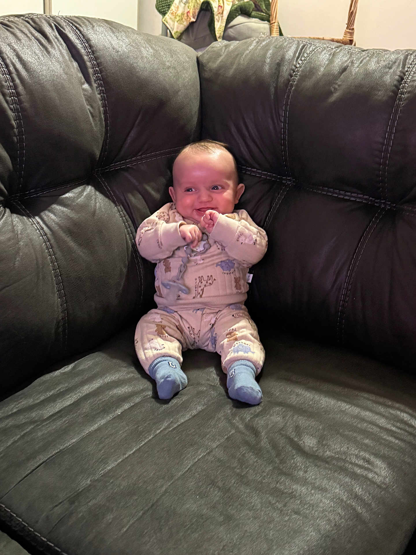 Eliseo joined the competition — help win amazing prizes! baby, infant, pajamas, leather_couch, smiling, sitting, indoors, child, cute, happy, person, furniture, home, cozy, sock, small_child, portrait, comfortable, playful, young