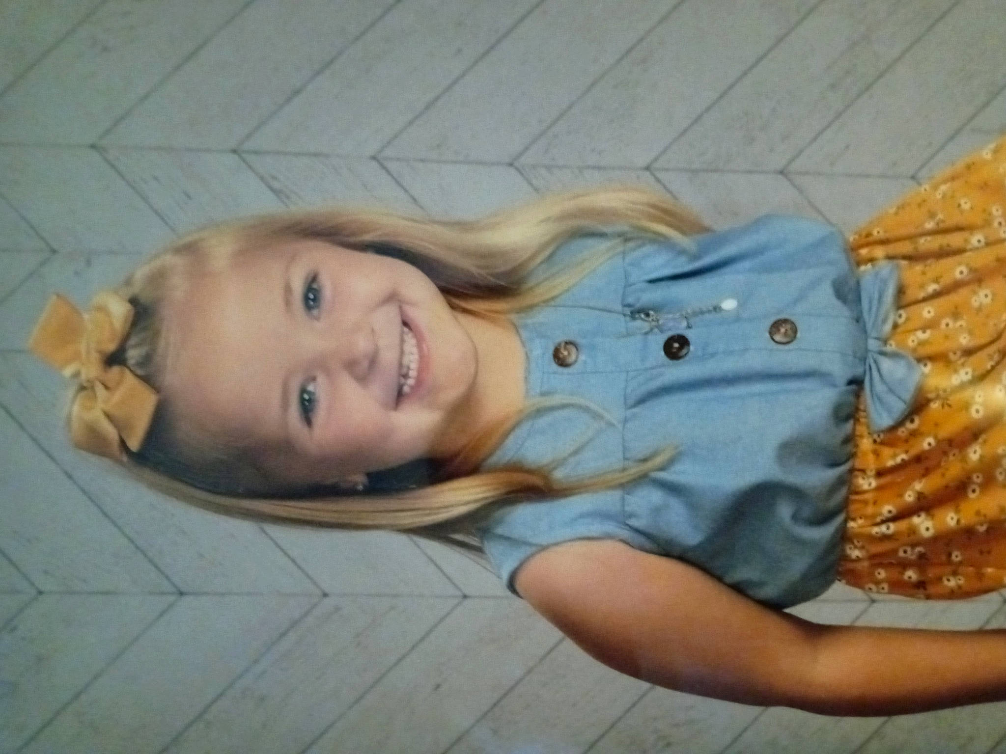 Kyndall is registered to the contest to win money with this photo: blond, child, eye, face, fawn, flooring, fun, grass, happy, head, joy, leisure, nose, organ, pattern, person, sitting, skin, smile, toddler