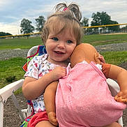 Avery joined the competition — help win amazing prizes! toddler, child, baby_doll, outdoor, grass, trees, cloudy_sky, chair, smiling, playing, pink_clothing, shorts, happy, portrait, person, nature, daylight, toy, cute, young_child