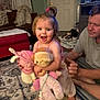 Avery is registered to the contest to win money with this photo: toddler, child, plush_toys, living_room, carpet, man, smile, toy, person, indoor, home, pajamas, curtains, furniture, door, rug, floor, hair_tie, couch, adult
