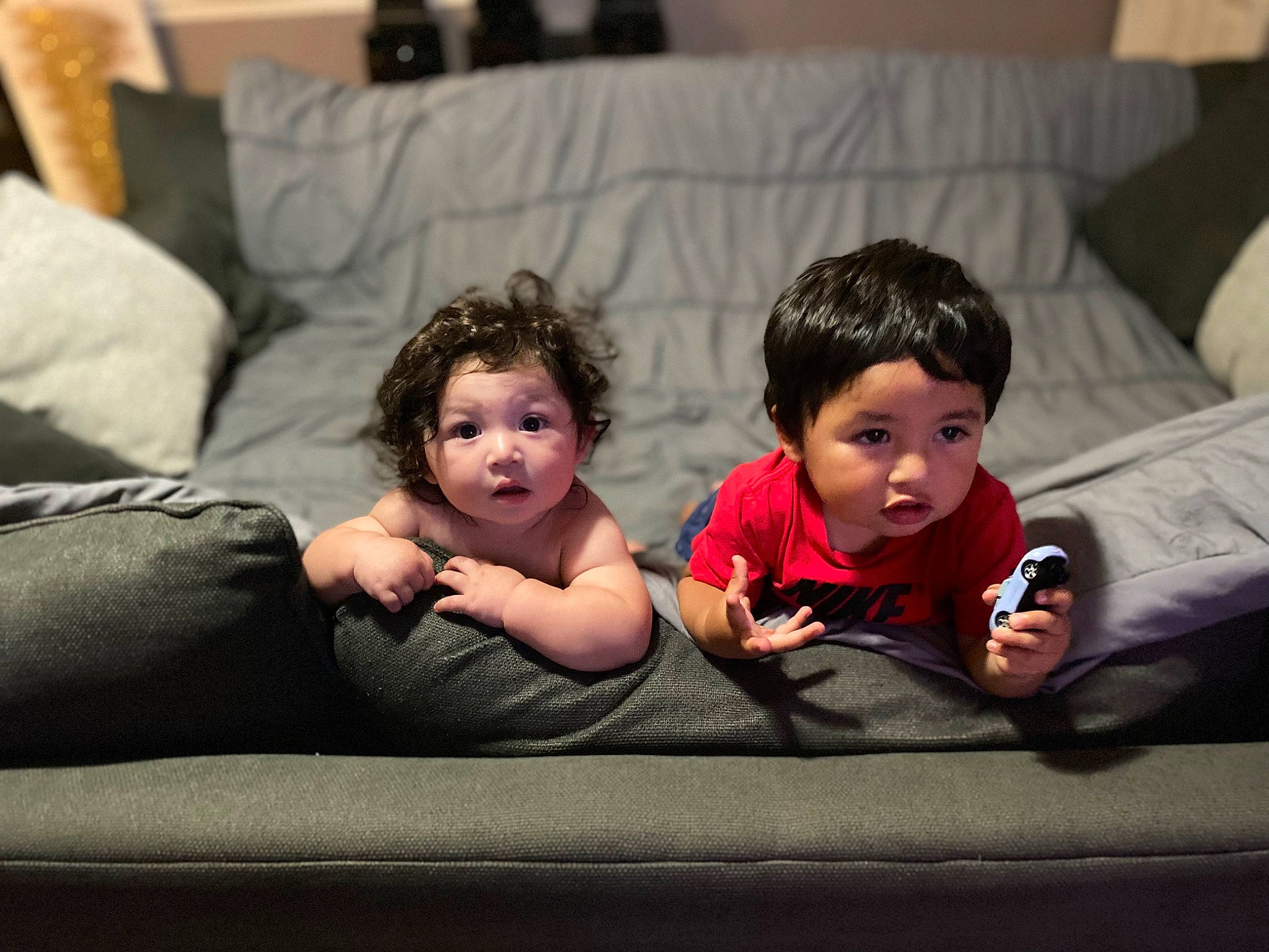 Moses is registered to the contest to win money with this photo: baby, cheek, child, comfort, couch, face, flash_photography, flooring, foot, fun, gesture, happy, head, interaction, leisure, living_room, people, person, sitting, surprise