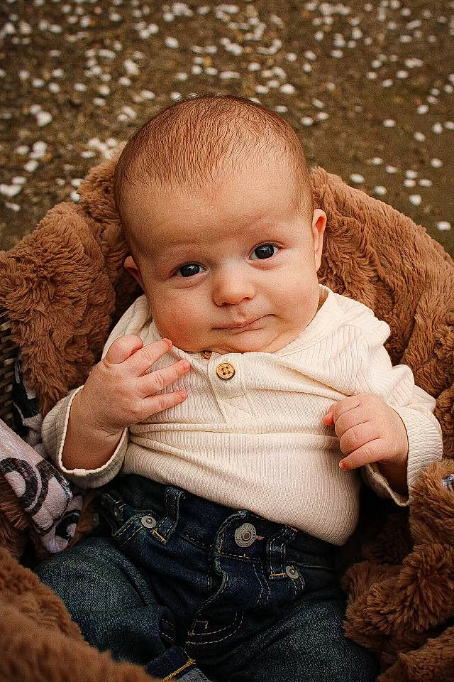 Lennox is registered to the contest to win money with this photo: baby, baby_toddler_clothing, brown, cheek, child, dress, eye, facial_expression, flash_photography, grass, happy, iris, lip, nose, outerwear, person, sitting, skin, toddler, wood