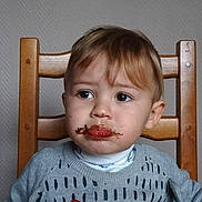 Aaron a rejoint le concours — aidez-le/la à gagner de superbes lots ! toddler, child, face, chair, sweater, food, messy, red_sauce, chocolate, spoon, table, indoor, portrait, expression, young_child, person, clothing, hair, looking_away, seated