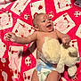 baby, infant, diaper, blanket, playing_cards, stuffed_animal, soft_toy, red, white, pattern, happy, smiling, face, laughter, cute, child, indoors, skin, head, lying_down