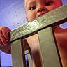 baby, child, infant, face, eyes, curious, crib, crib_rail, nursery, indoor, portrait, close_up, low_angle, gripping, standing, wood, metal, purple_lighting, safe, photography