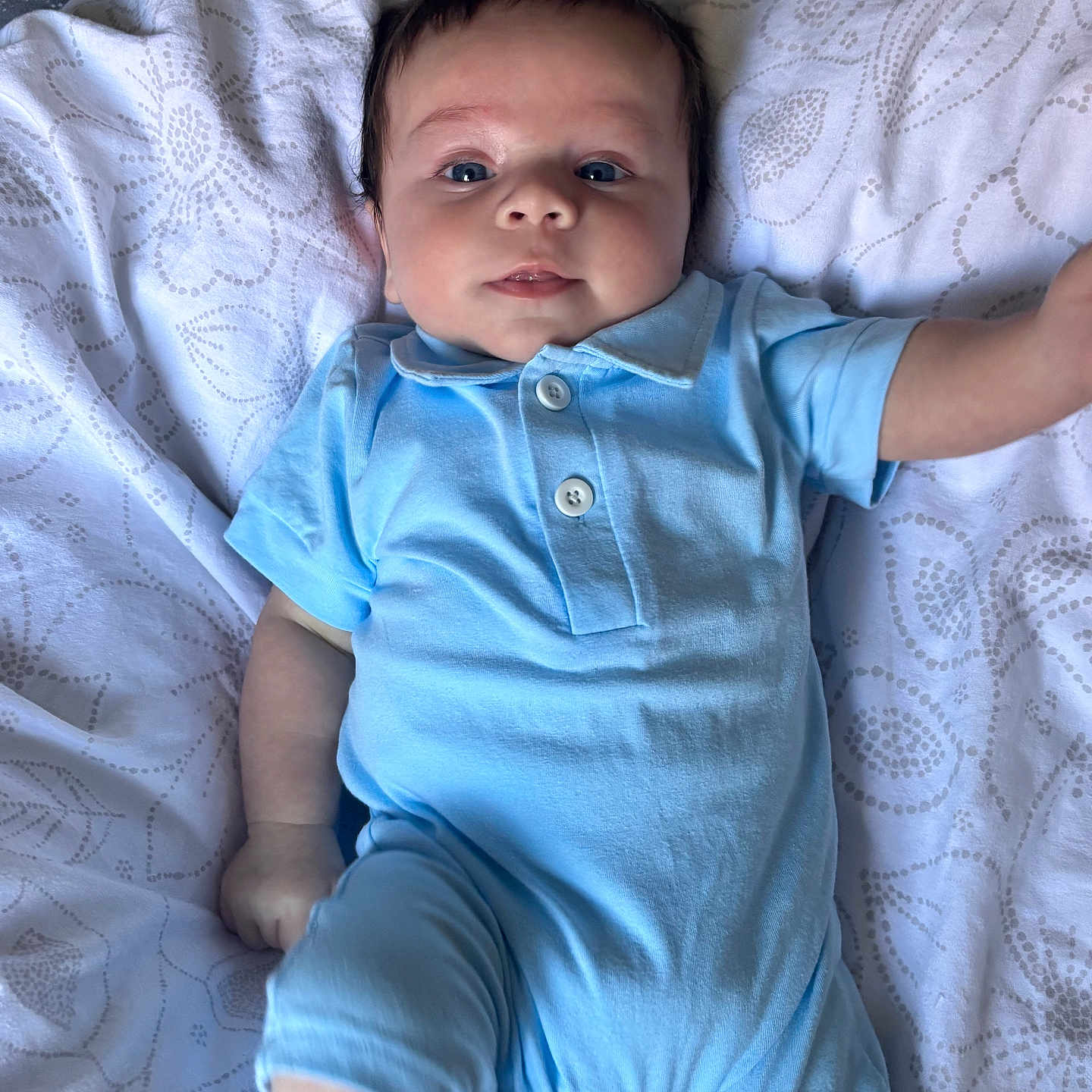 Ezio participe au concours pour gagner de l'argent avec cette photo : arm, baby, blanket, blue_onesie, cheeks, child, clothing, cute, eyes, face, indoors, infant, leg, lying_down, patterned_blanket, portrait, skin, smile, soft_light, young