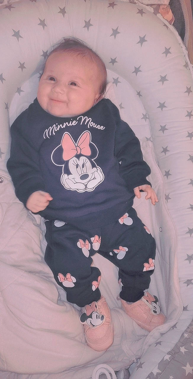 Ines participe au concours pour gagner de l'argent avec cette photo : baby, baby_toddler_clothing, cheek, chin, comfort, face, hand, head, human_body, joy, leg, mouth, person, pink, product, skin, sleeve, smile, standing, textile