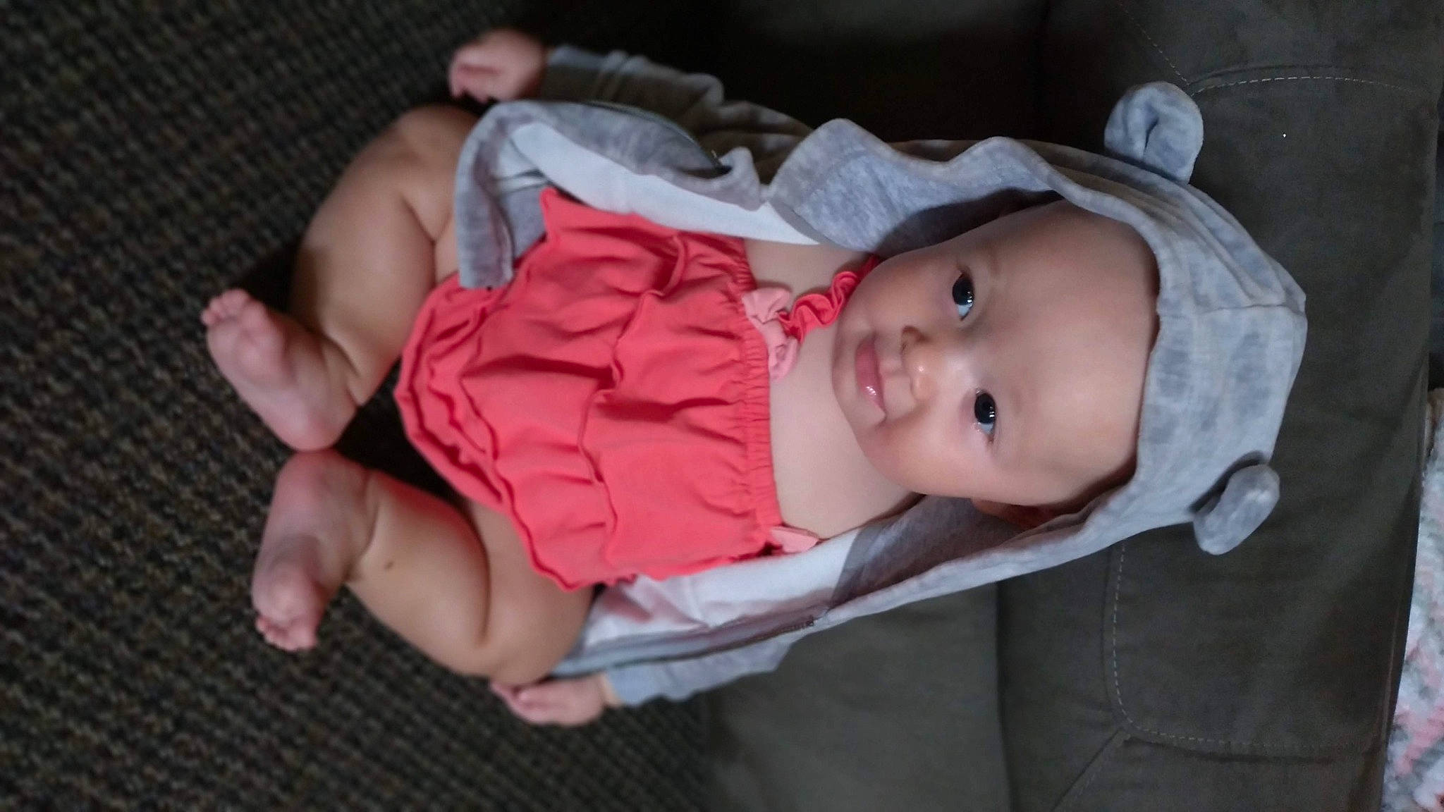 Remi is registered to the contest to win money with this photo: baby, baby_products, baby_toddler_clothing, cheek, child, comfort, eye, finger, gesture, grass, headwear, iris, lip, mouth, nose, pattern, person, sitting, skin, sleeve