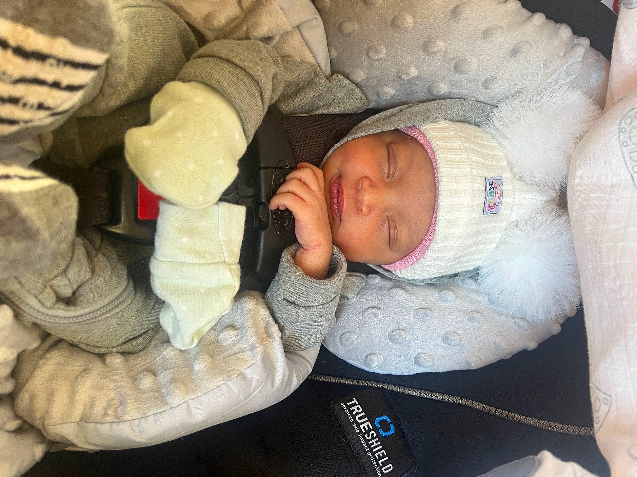 Amila is registered to the contest to win money with this photo: arm, baby, baby_products, baby_toddler_clothing, cheek, child, comfort, eye, finger, gesture, hand, head, headgear, headwear, human_body, mouth, nose, person, sitting, skin