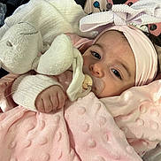 Maïna a rejoint le concours — aidez-le/la à gagner de superbes lots ! baby, infant, child, pacifier, stuffed_animal, plush_toy, headband, bow, pink_blanket, blanket, hand, eyes, face, portrait, cozy, swaddled, newborn, gaze, clothing, bedding