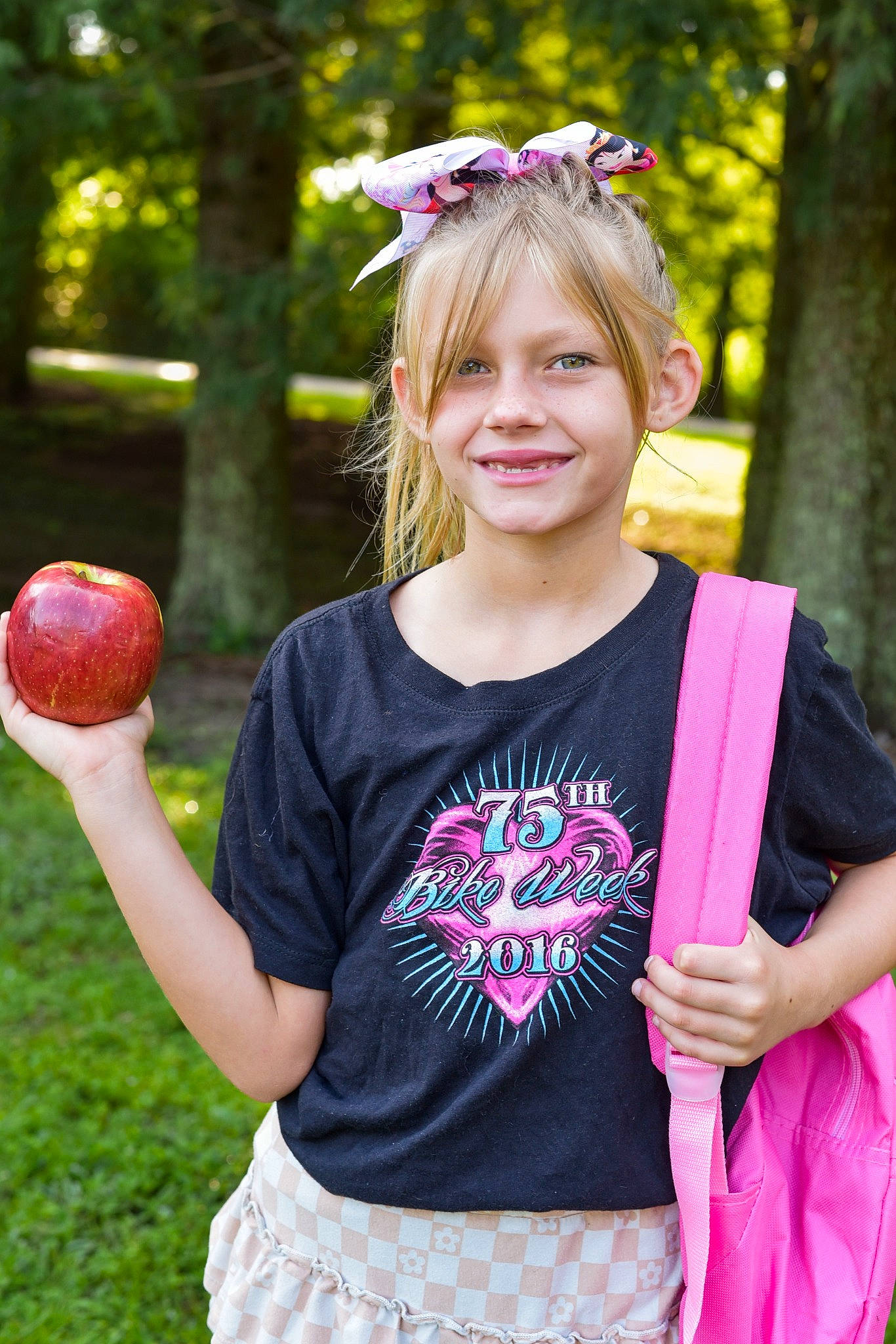 Mollie is registered to the contest to win money with this photo: ball, botany, facial_expression, fun, grass, green, happy, joy, leaf, leisure, people_in_nature, person, photograph, pink, plant, shoulder, sleeve, smile, standing, summer