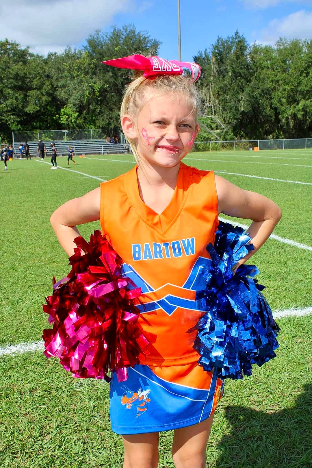 Mollie is registered to the contest to win money with this photo: blue, brown_hair, cheerleading_uniform, cloud, electric_blue, event, fun, grass, joy, person, plant, player, recreation, sky, smile, sports, summer, team, team_sport, tree