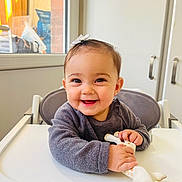 Esmée a rejoint le concours — aidez-le/la à gagner de superbes lots ! baby, child, high_chair, smile, toy, giraffe_toy, bow, indoor, happy, cute, person, face, clothing, sitting, infant, teething, hand, table, window, furniture