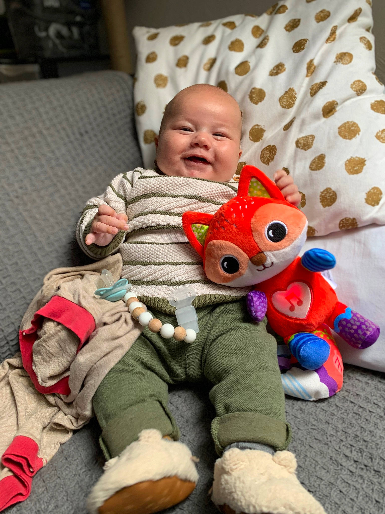 Raphaël participe au concours pour gagner de l'argent avec cette photo : baby, baby_products, baby_toddler_clothing, child, comfort, couch, flooring, fun, happy, lap, linens, person, play, plush, room, sitting, skin, smile, stuffed_toy, toddler