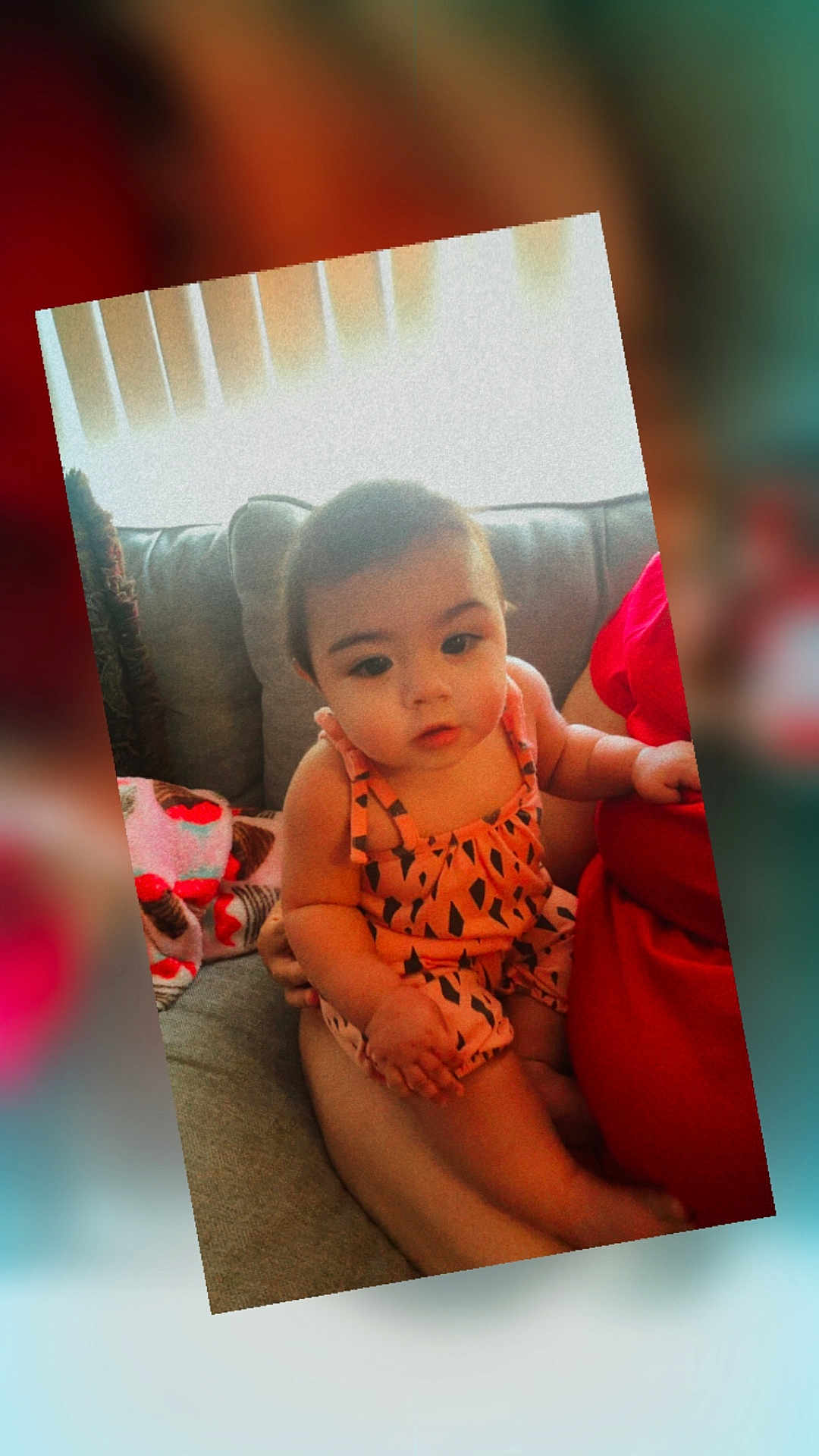 Erinyes joined the competition — help win amazing prizes! baby, infant, child, person, couch, indoor, clothing, patterned, romper, sitting, lap, curious, face, portrait, cute, warm_tones, soft_focus, home, blanket, adult_arm
