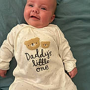 Riley joined the competition — help win amazing prizes! baby, baby_boy, baby_girl, blanket, child, clothing, cute, face, happy, indoors, infant, lying_down, newborn, onesie, portrait, skin, sleepwear, smiling, teddy_bear, text_on_clothing