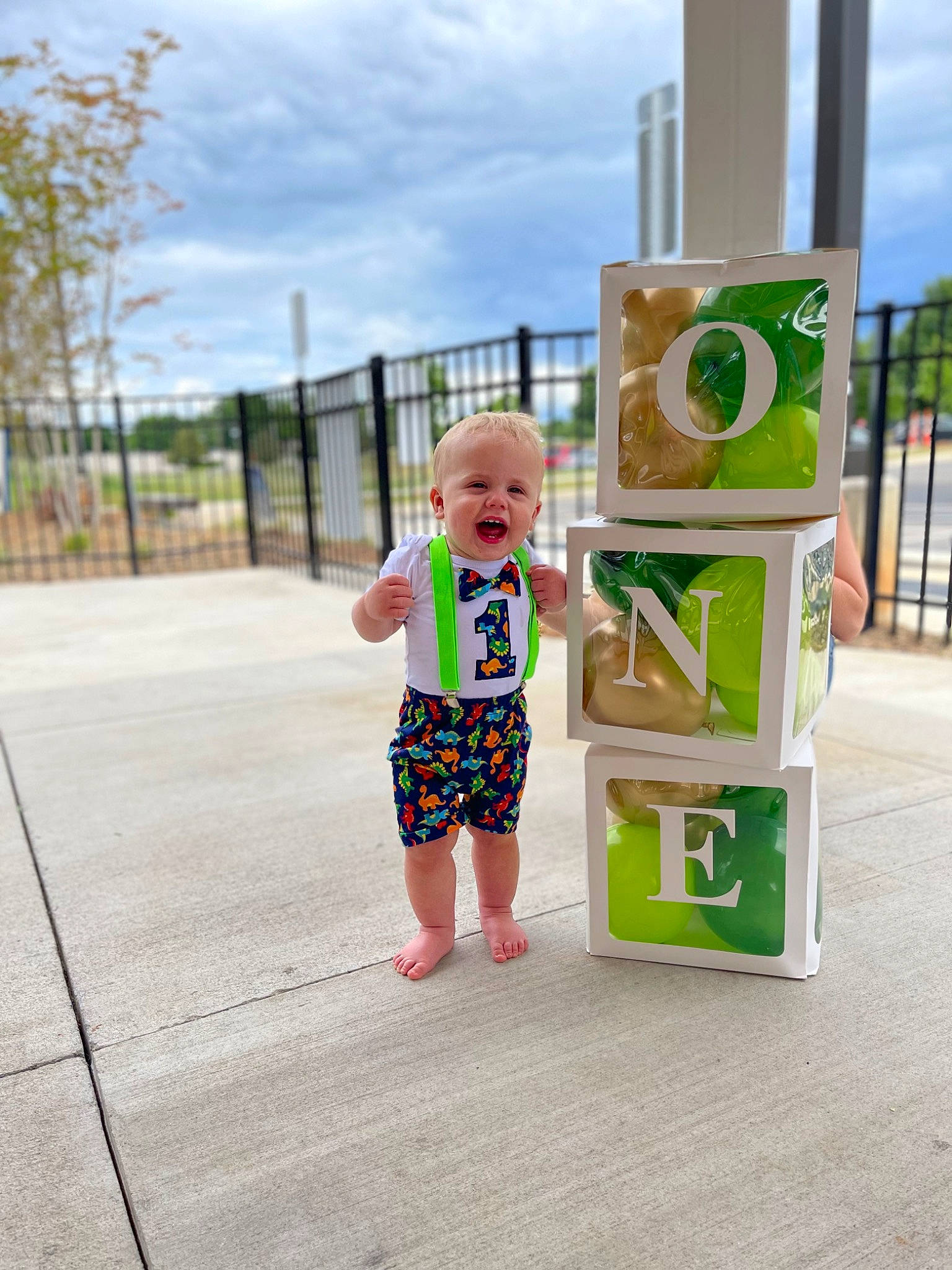 Braxton is registered to the contest to win money with this photo: asphalt, baby, baby_toddler_clothing, child, city, cloud, fence, fun, grass, happy, leisure, person, plant, recreation, sky, sleeve, smile, street_fashion, t_shirt, toddler