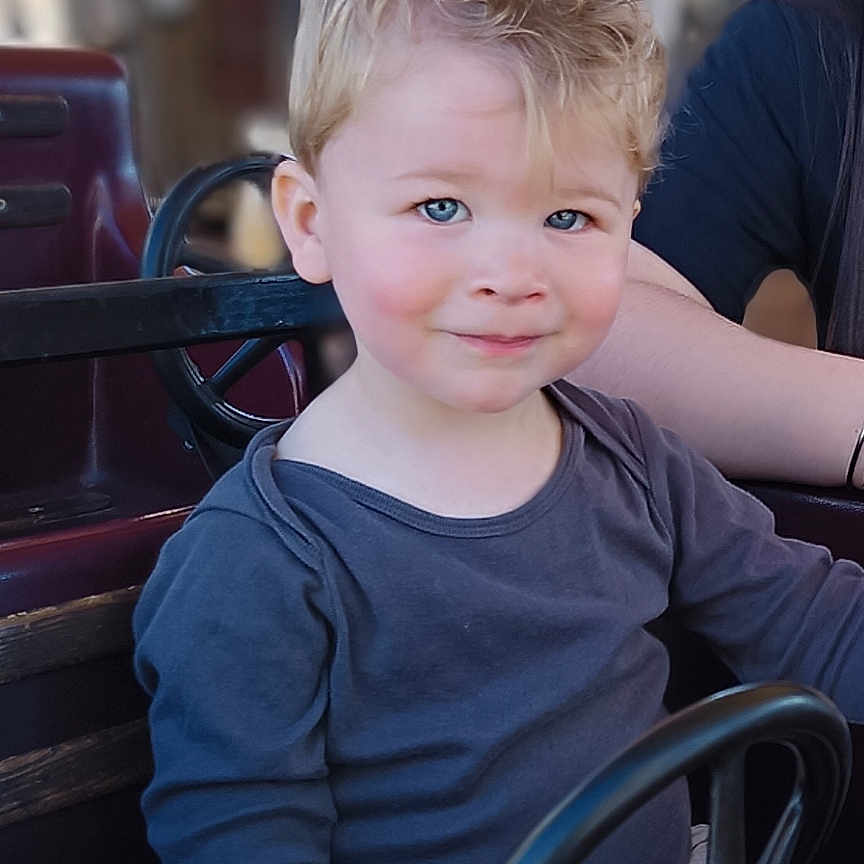 Eden a rejoint le concours — aidez-le/la à gagner de superbes lots ! adult, bodypart, boy, child, driving, face, finger, hand, head, machine, male, man, person, photography, portrait, sitting, spoke, transportation, vehicle, wheel