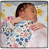 baby, sleeping, infant, pajamas, floral_pattern, blanket, bed, soft_toys, teddy_bear_pattern, peaceful, closeup, face, hand, cute, child, resting, indoors, portrait, newborn, cozy