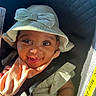 baby, child, smiling, hat, bow, car_seat, seatbelt, sunlight, happy, cute, infant, clothing, fabric, hand, face, eyes, mouth, skin, portrait, baby_accessory