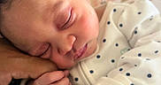 Nasya is registered to the contest to win money with this photo: adult_hand, baby, closeup, cuddle, curly_hair, cute, face, finger, floral_background, hand, infant, newborn, peaceful, polka_dot, portrait, resting, skin, sleeping, soft_light, white_clothing