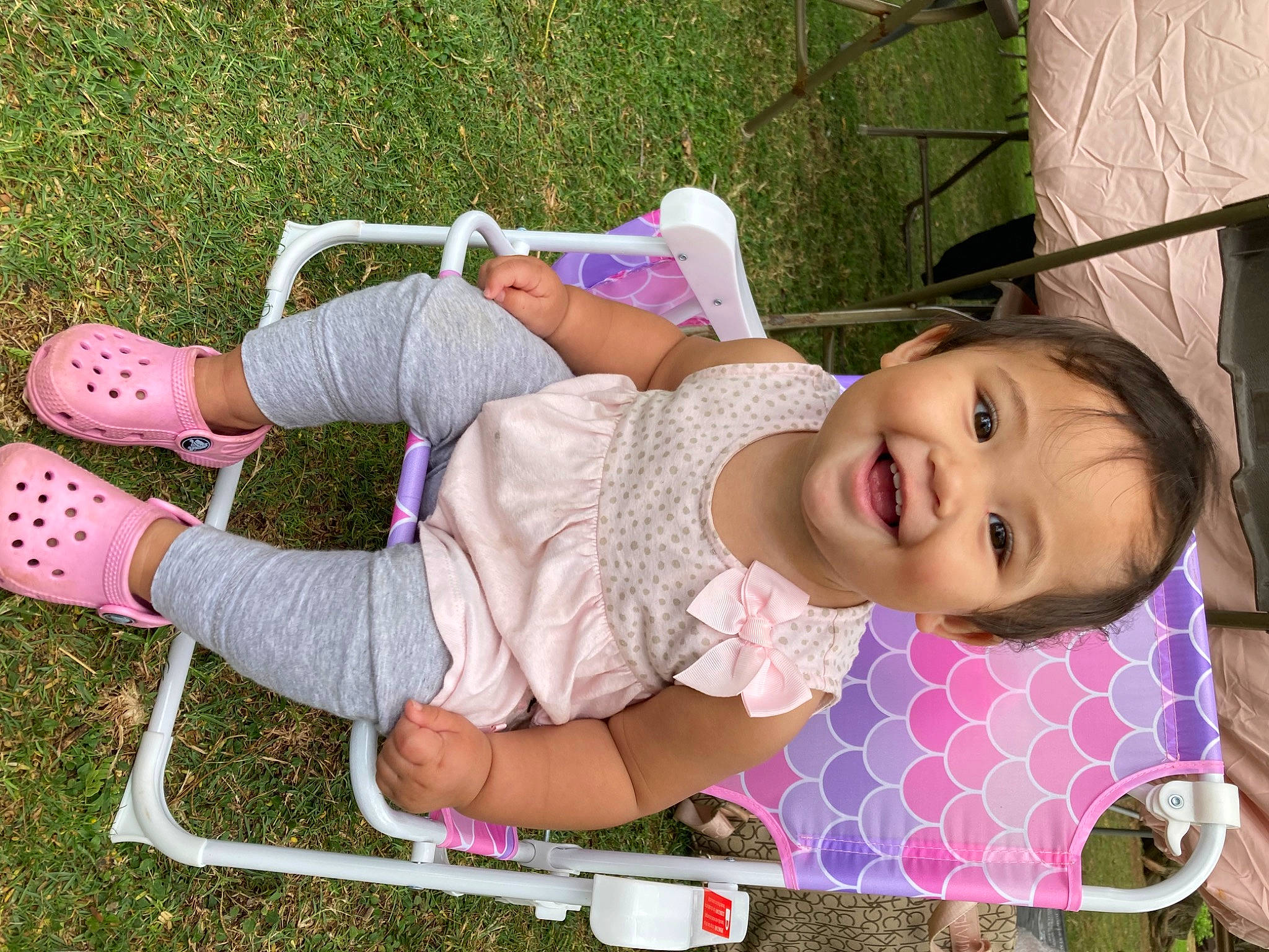 Blake is registered to the contest to win money with this photo: baby, baby_toddler_clothing, beauty, child, dress, fun, grass, happy, human_leg, joy, leg, leisure, magenta, pattern, person, pink, plant, product, recreation, skin