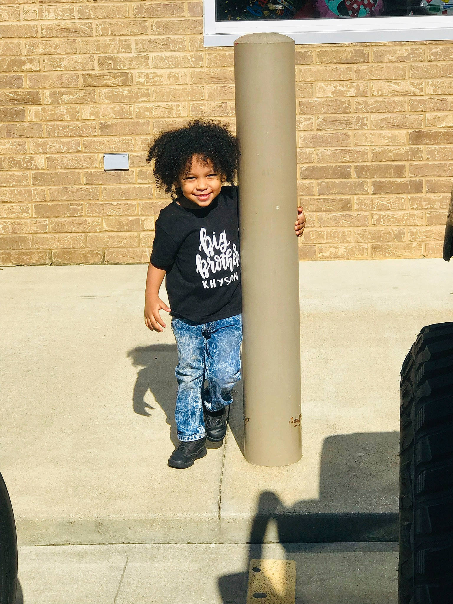 Khyson is registered to the contest to win money with this photo: child, cool, jeans, joy, person, shoe, snapshot, standing, t_shirt, toddler, top, vacation, wall