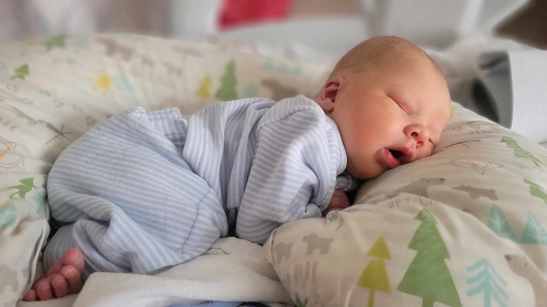 Graham is registered to the contest to win money with this photo: baby, newborn, sleeping, pajamas, striped_clothing, pillow, bed, blanket, soft_fabric, infant, peaceful, cute, face, skin, rest, indoors, child, head, comfort, cozy