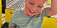 Arthur joined the competition — help win amazing prizes! child, boy, smiling, playground, outdoor, greenery, sunlight, short_sleeve_shirt, toddler, happy, wood_chips, metal_bench, yellow, casual_clothing, playing, summer, fun, daylight, park, closeup