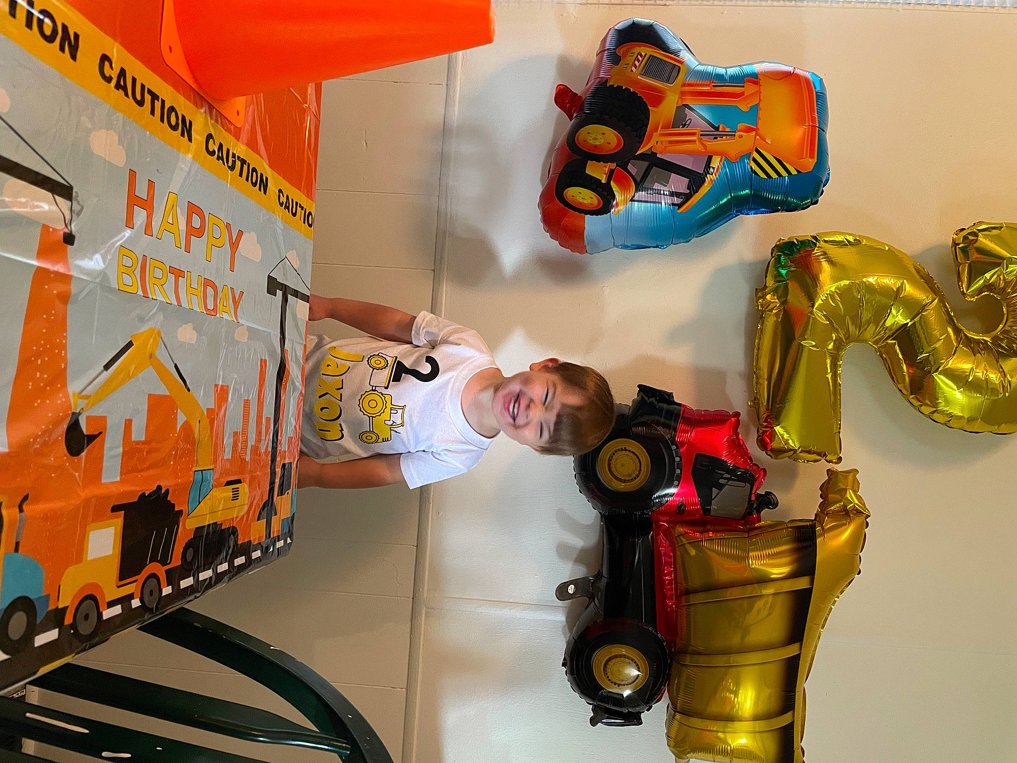 Jaxon is registered to the contest to win money with this photo: art, automotive_design, automotive_exterior, child, commercial_vehicle, fictional_character, fun, joy, leisure, machine, motor_vehicle, person, product, recreation, room, t_shirt, tire, toy, truck, visual_arts