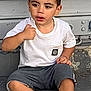 Aylan participe au concours pour gagner de l'argent avec cette photo : child, boy, sitting, white_tshirt, shorts, sneakers, urban, step, metal_shutter, casual_clothing, outdoor, young_child, portrait, thoughtful, street, concrete, sign, black_socks, hair, face
