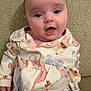 baby, infant, pajamas, animal_print, cute, face, eyes, mouth, couch, fabric, texture, clothing, child, sitting, indoor, soft_lighting, skin, expression, young, adorable
