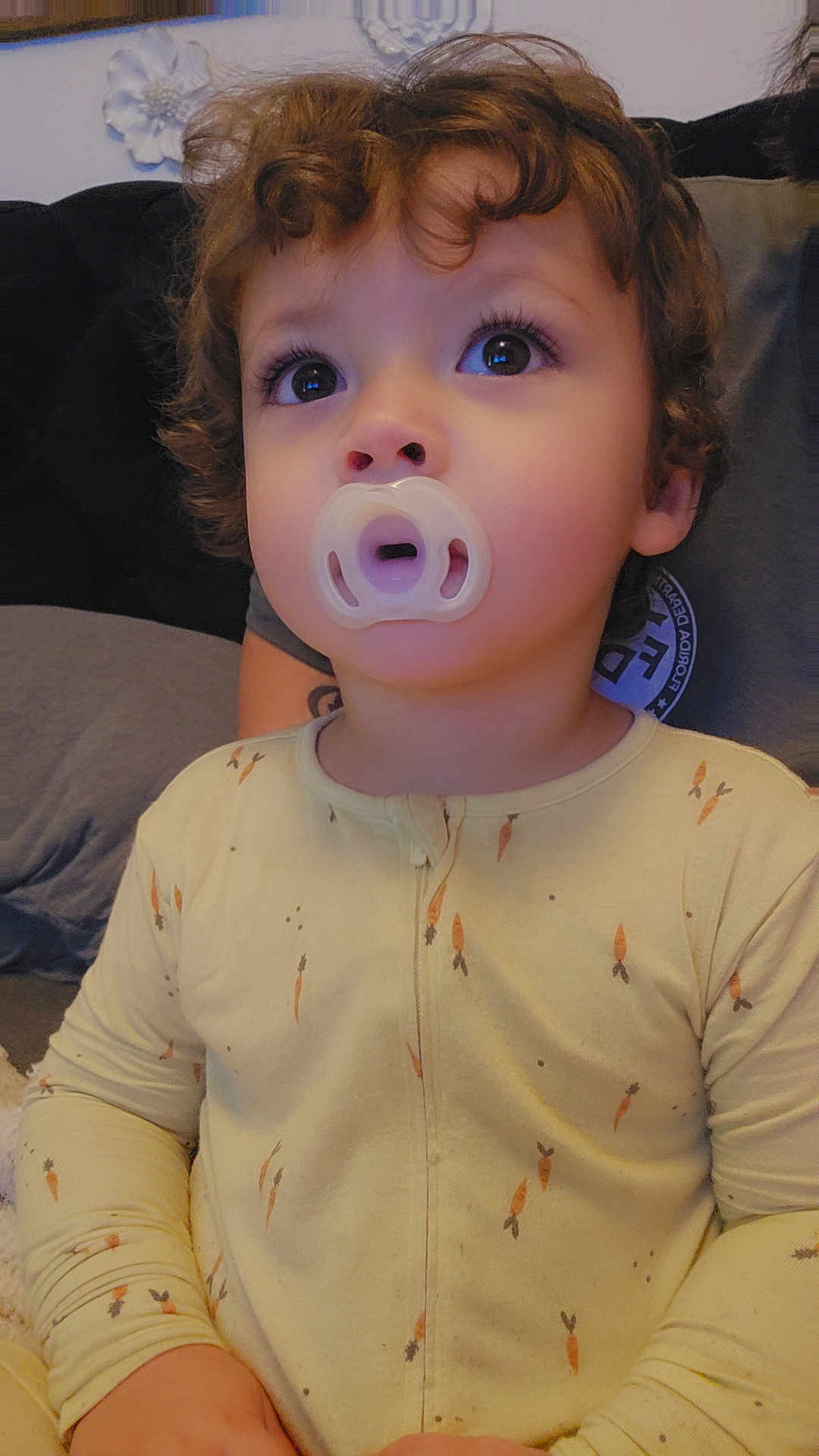 Domenick joined the competition — help win amazing prizes! toddler, child, pacifier, curly_hair, pajamas, carrot_print, indoor, portrait, cute, young_child, expression, close_up, face, person, sitting, home, cozy, clothing, soft_light, curiosity
