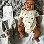 baby, infant, child, smiling, dinosaur_onesie, plush_bunny, soft_toy, footprint_card, three_months_card, gray_blanket, knit_blanket, lying_down, top_view, happy, cute, hands, legs, fabric_texture, portrait, indoor
