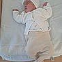 baby, newborn, sleeping, infant, knitwear, headband, bow, towel, wooden_surface, peaceful, soft_texture, clothing, cute, resting, indoors, child, person, portrait, white, beige