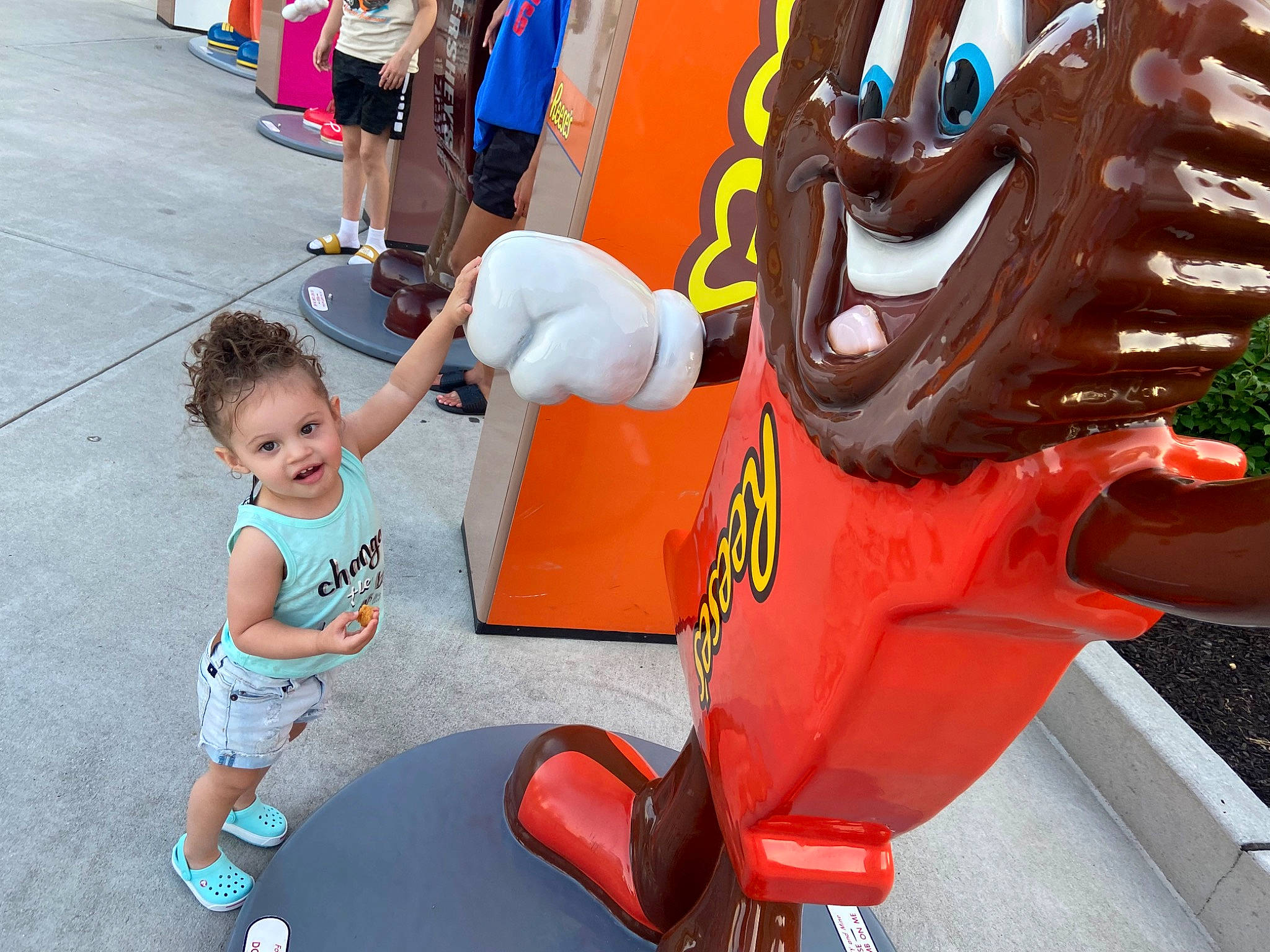 Adalyn is registered to the contest to win money with this photo: event, fun, human_settlement, leg, leisure, mammal, mascot, orange, person, photograph, pink, public_space, recreation, red, sandal, shorts, snapshot, sneakers, t_shirt, toddler