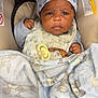 baby, bib, blanket, bundle, car_seat, child, clothing, comfort, cute, face, hat, indoor, infant, newborn, pacifier, portrait, seat, serious_expression, soft_texture, warning_label