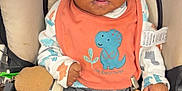 Mekhi joined the competition — help win amazing prizes! baby, bib, blue_socks, car_seat, child, clothing, curious_expression, cute, dinosaur, grey_pants, holding, indoor, infant, orange_bib, person, plush_toy, portrait, seat, toddler, young_child