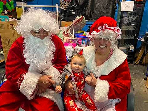 Rebel is registered to the contest to win money with this photo: beard, christmas, christmas_eve, costume, costume_hat, event, fictional_character, fun, fur, happy, hat, headwear, holiday, joy, lap, mammal, person, red, santa_claus, smile