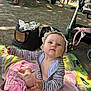 Nina-Rose a rejoint le concours — aidez-le/la à gagner de superbes lots ! baby, child, outdoor, blanket, sun_hat, striped_clothing, reaching_hand, picnic, stroller, people, trees, shade, bags, summer, playful, nature, grass, feet, toddler, relaxing