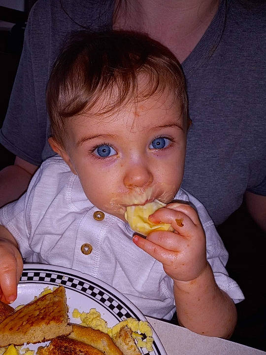 Tamryn is registered to the contest to win money with this photo: biting, chair, child, comfort_food, cuisine, dish, eating, fast_food, finger_food, food, food_craving, fried_food, ingredient, junk_food, person, plate, sharing, staple_food, tableware, toddler