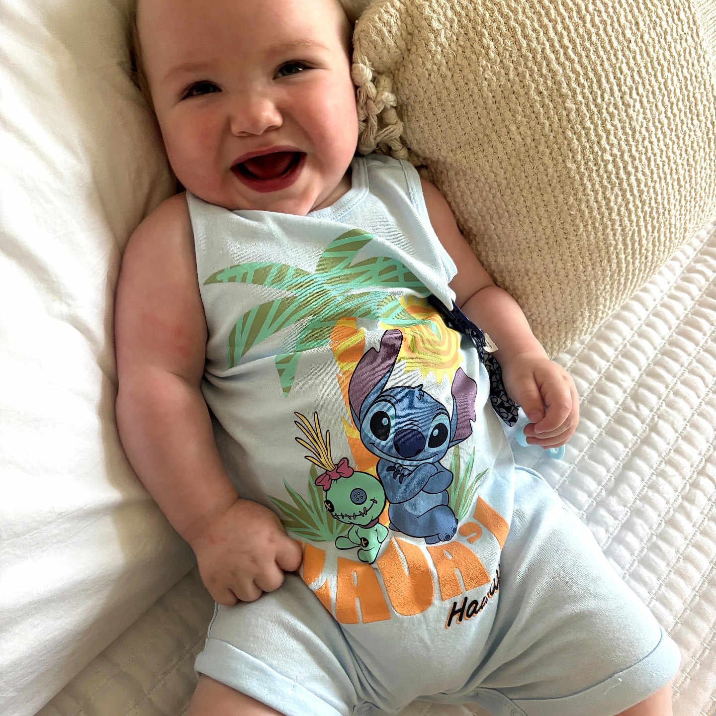Jaxx joined the competition — help win amazing prizes! baby, smiling, infant, romper, cartoon_print, bed, pillow, white_bedspread, comfort, happy, child, cute, indoors, person, skin, head, arms, legs, clothing, lying_down