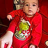 Elijiah is registered to the contest to win money with this photo: baby, child, infant, red_clothing, grinch, holiday_theme, cushion, comic_art, hand, person, indoors, portrait, cute, wide_eyes, expression, seated, resting, comfort, closeup, soft_lighting