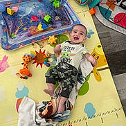 Elijiah is registered to the contest to win money with this photo: baby, infant, play_mat, toy, water_play_pad, smiling, cute, child, indoors, colorful, clothing, happy, floor, blanket, crawling, playtime, face, person, small_toy, pajamas