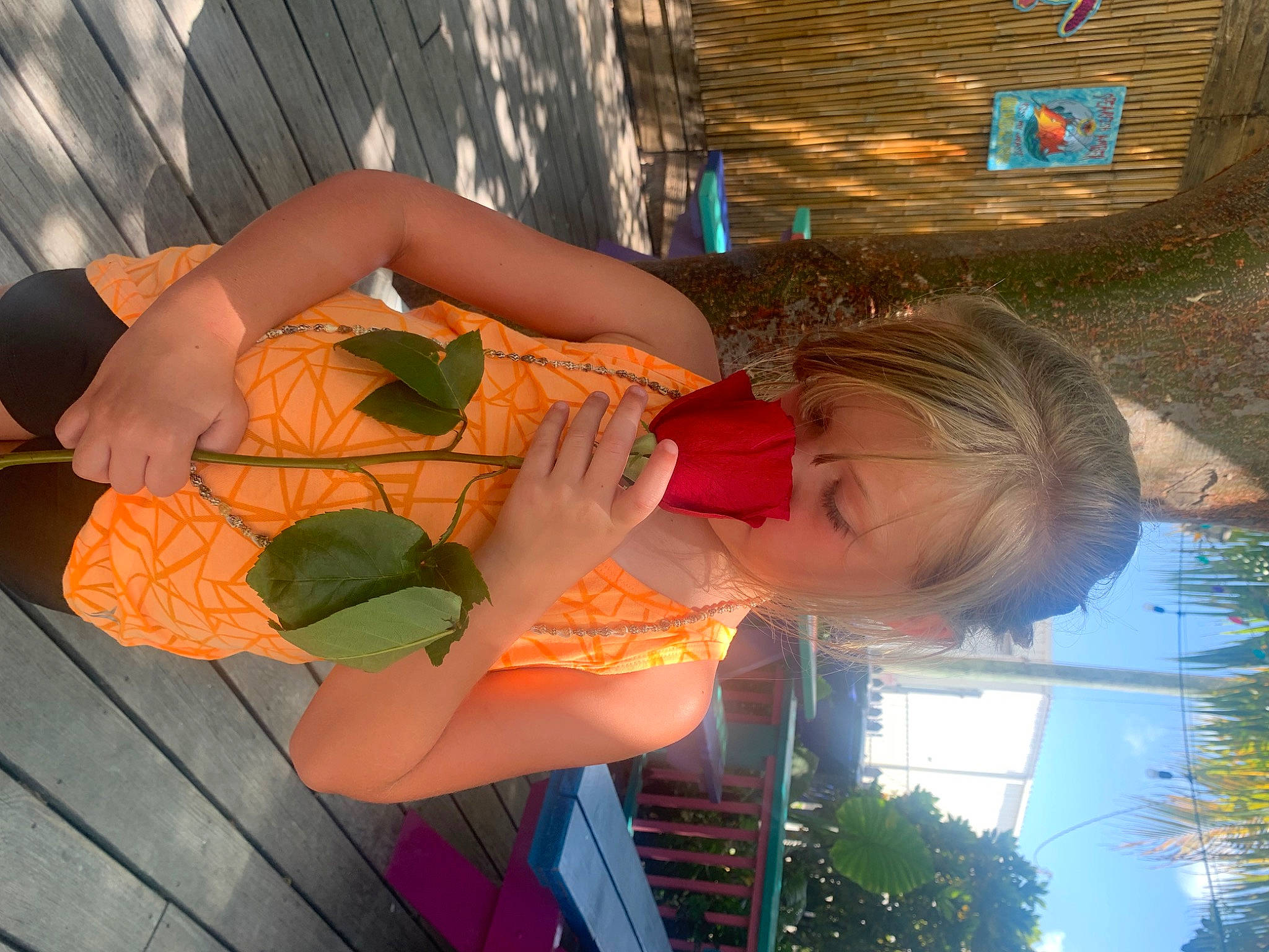 Kadence is registered to the contest to win money with this photo: beauty, child, eyewear, fun, grass, happy, human_leg, leisure, orange, person, plant, sitting, smile, sunglasses, thigh, tree, vacation, water